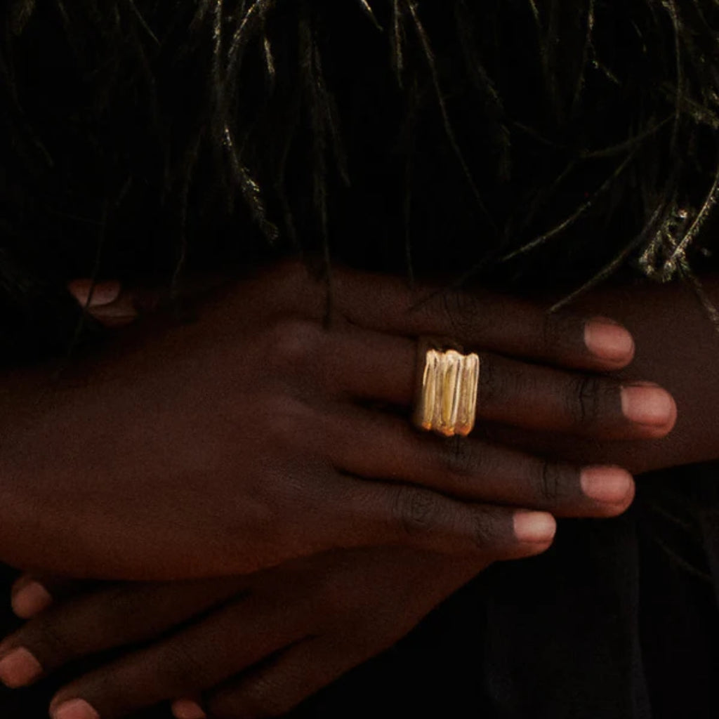 Close-up of a hand wearing a gold ring Granite Ring Brass Ariana Boussard-Reifel
