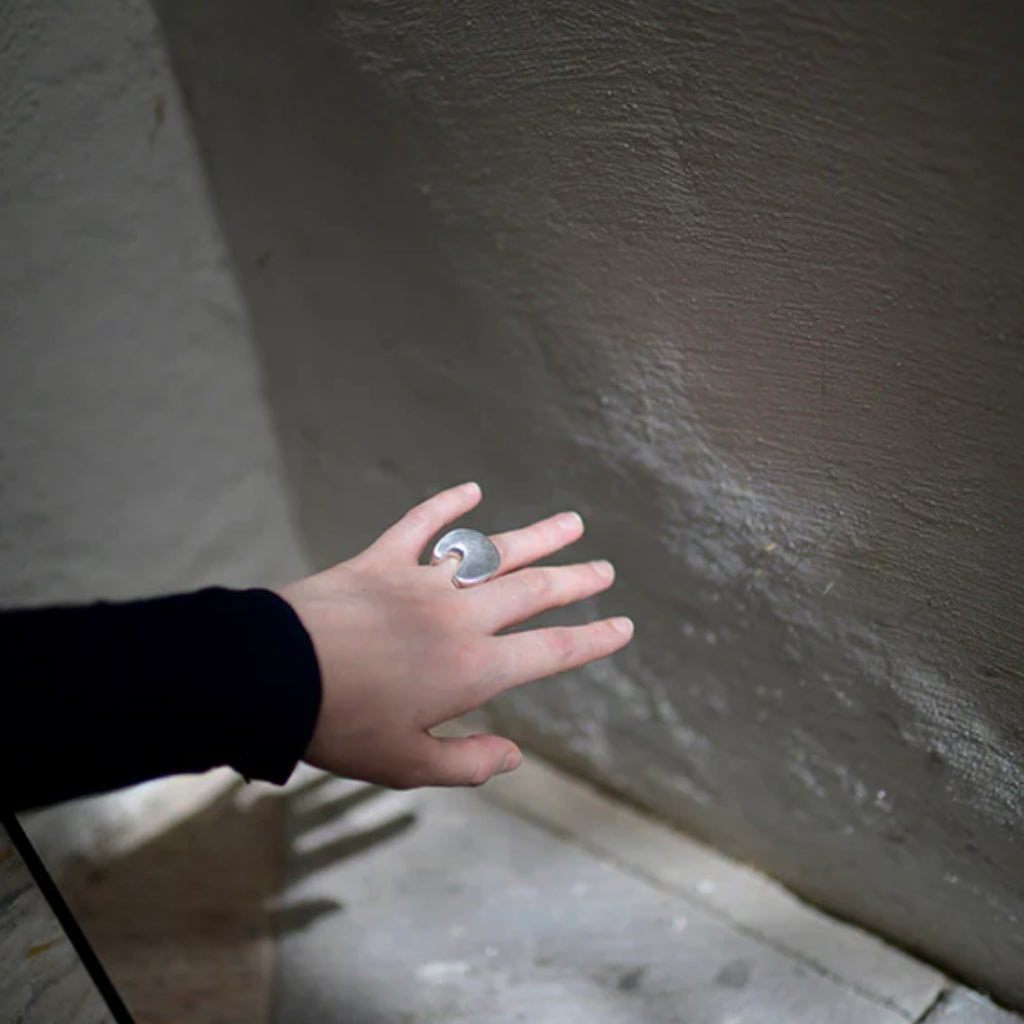 Hand with a ring on a textured wall