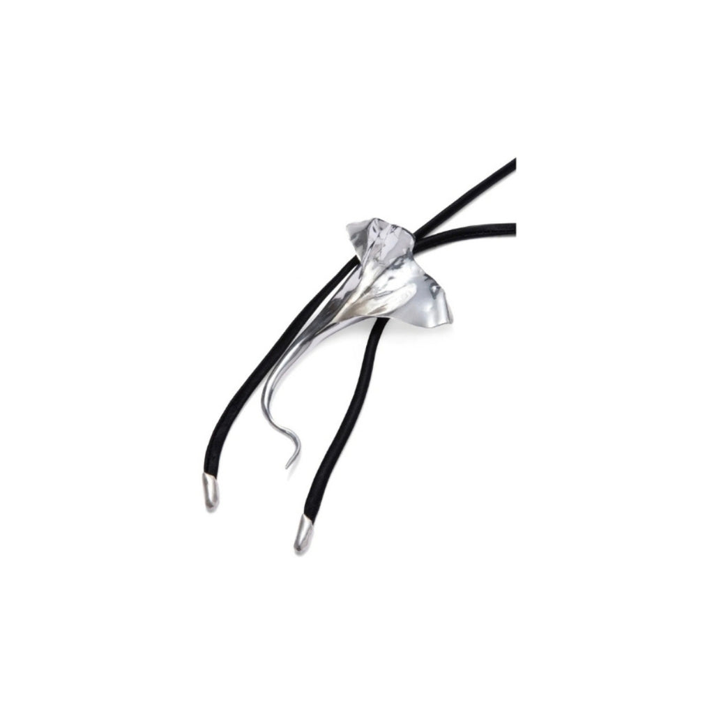 Close-up of a silver floral pendant on a black cord necklace.