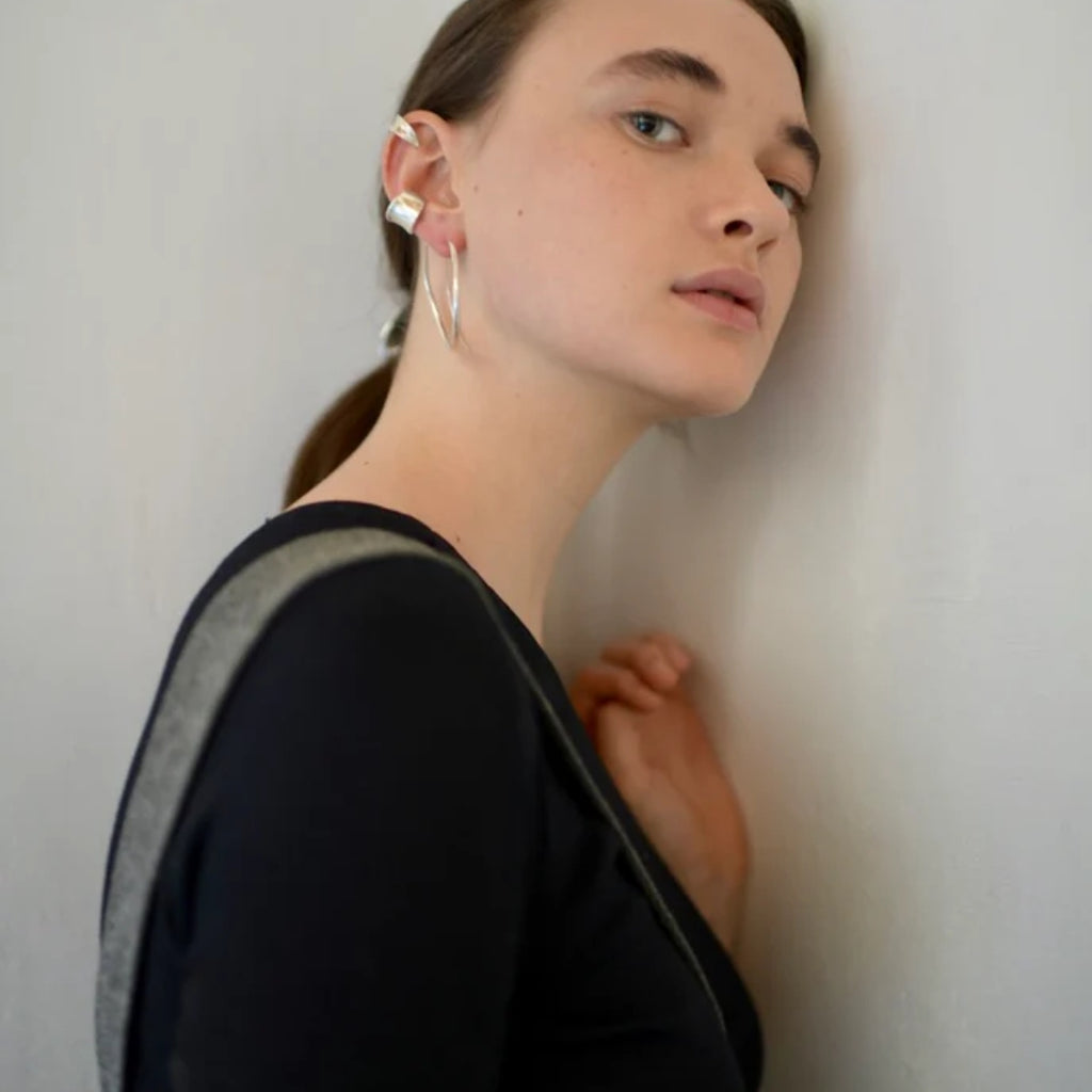 Person wearing earrings against a plain background