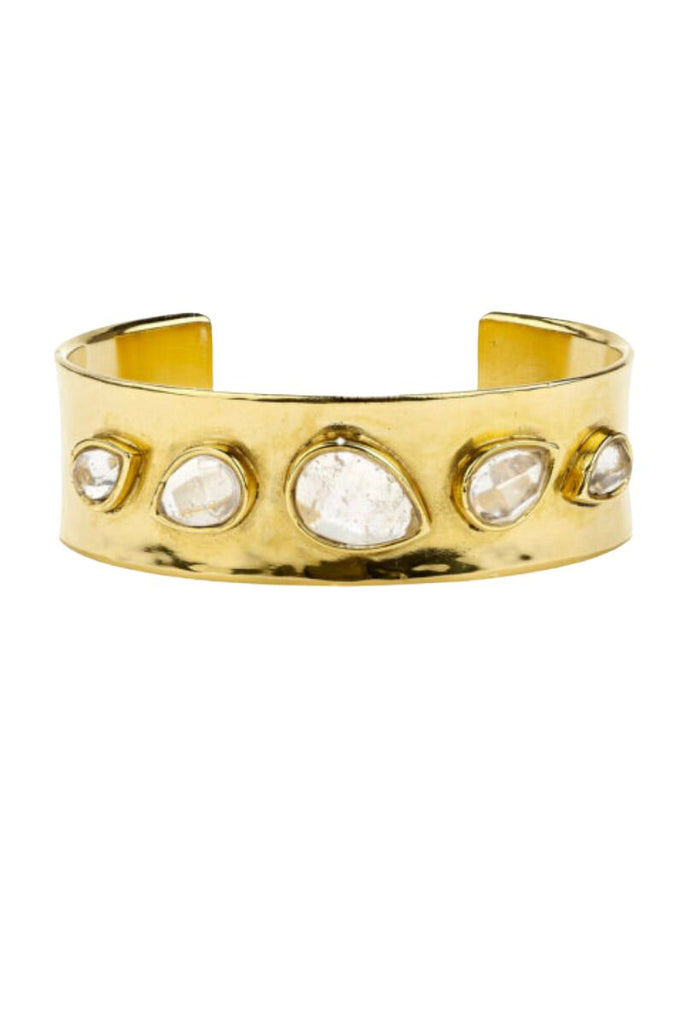 The Cachemire Bracelet features a chunky and bold silhouette with shimmering rock crystals, crafted with intricate details and a brass base soaked in 24-carat gold, making it a perfect statement piece that can be worn alone or layered with other bracelets.