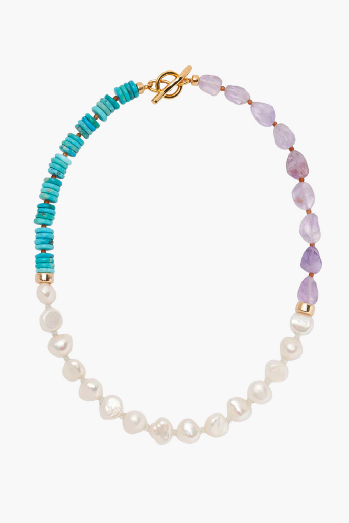 Embrace the captivating coastal charm of the Chama Necklace in Amethyst by Lizzie Fortunato, featuring a colorful beaded collar design of natural gemstones and a gold-plated brass toggle closure.