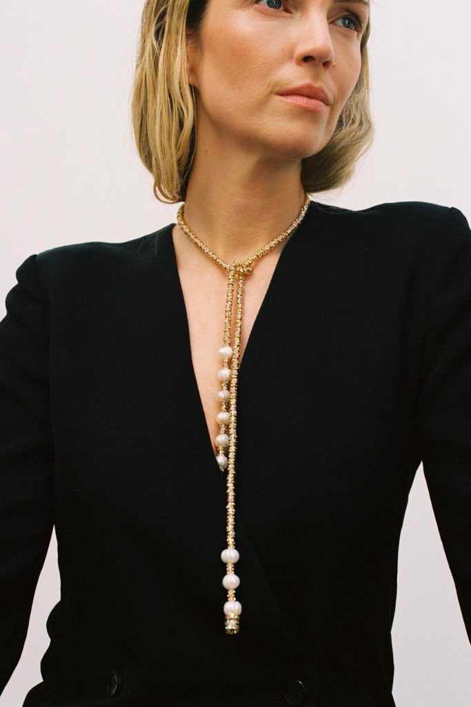 Add a touch of elegance to your look with the Pearl Octopuss.y Coco Necklace, featuring a tie-inspired chain with gold-plated copper beads, light-reflecting glass crystals, and potato-shaped freshwater pearls.