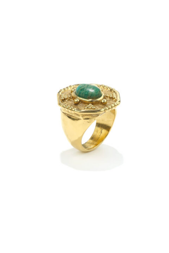 The Essaouira Signet Ring by Goossens Paris is a bold statement piece inspired by Moroccan Berber jewelry, featuring a cabochon-cut amazonite stone set in raw golden brass soaked in 24-carat gold.