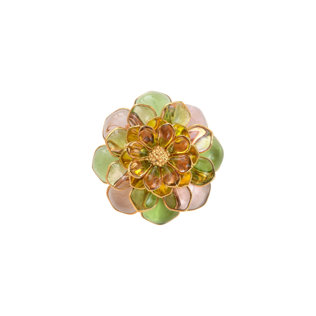 A vintage Gripoix flower brooch with a brass and glass construction, featuring a green and pink color scheme.