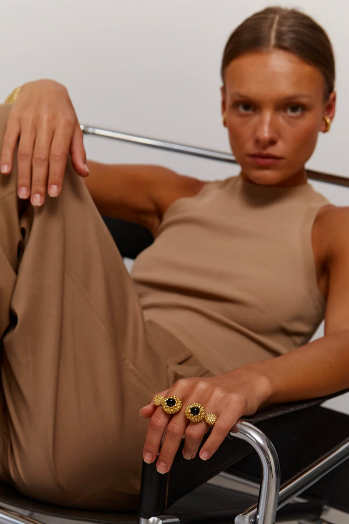 The Karpos Ring, designed by Paola Sighinolfi in collaboration with Patrizia Casarini, is a handcrafted black stone ring adorned with gold-plated metal bubbles inspired by the Mediterranean coast, evoking the natural beauty of the Cadaqués coves and creating a timeless and contemporary piece of jewelry.