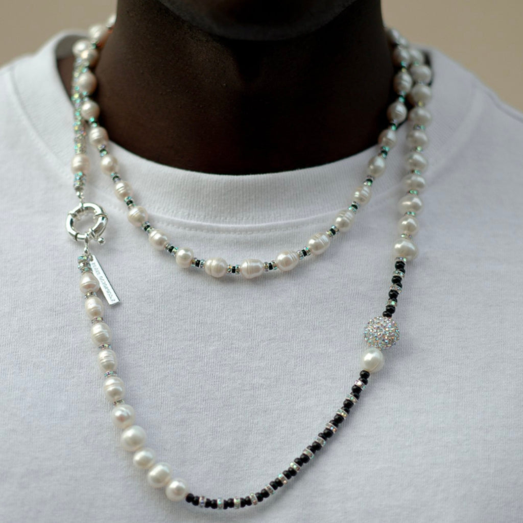 Pearl and black beaded necklace on a white shirt