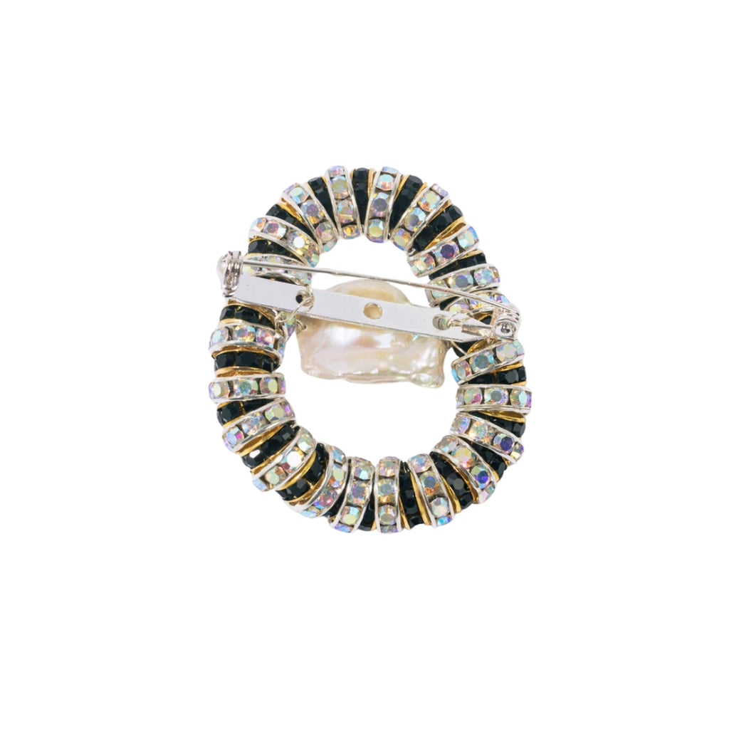 Circular brooch with multicolored gemstones on a white background