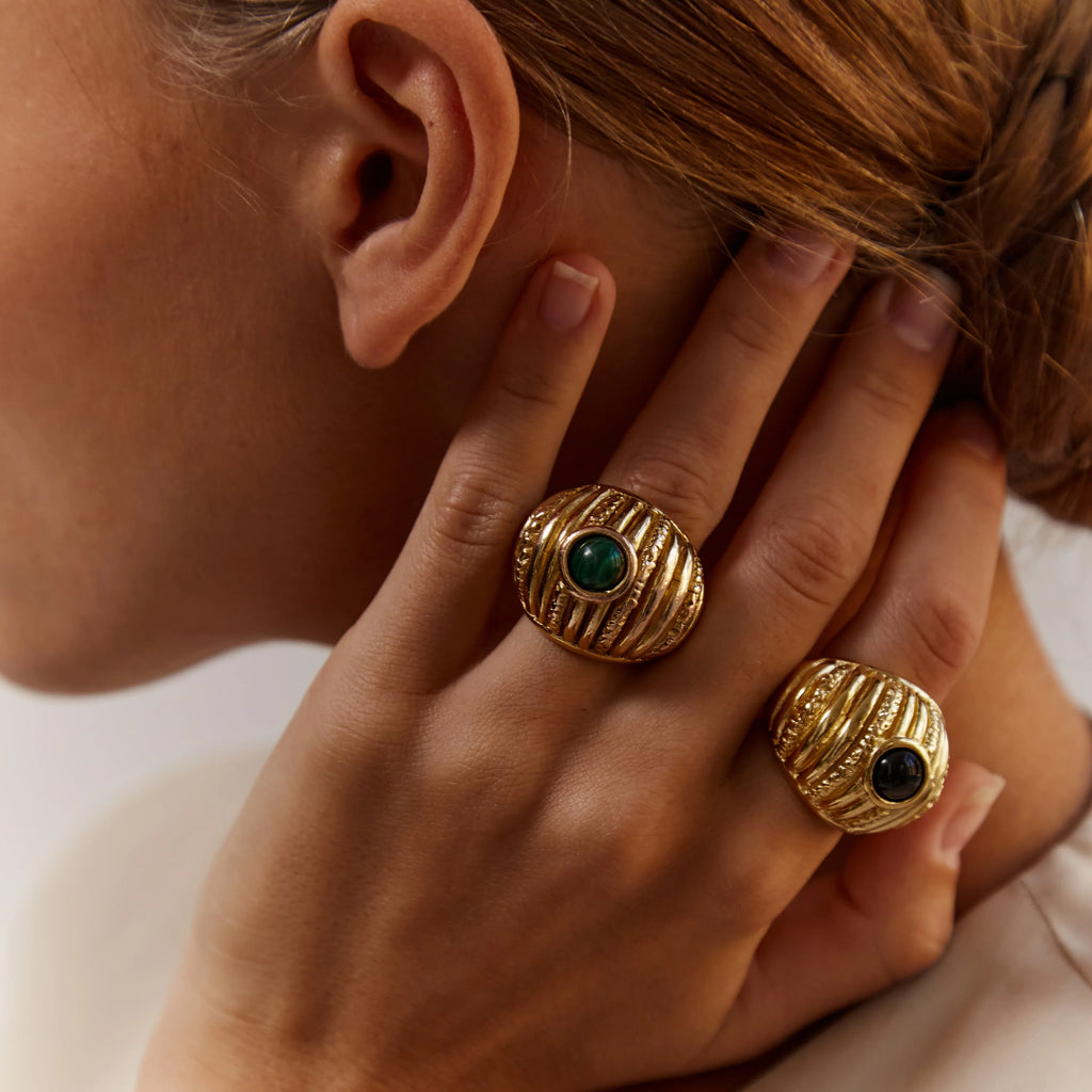 Close-up of a person wearing Paola Sighinolfi Reef Ring Malachite and Reef Ring Onyx