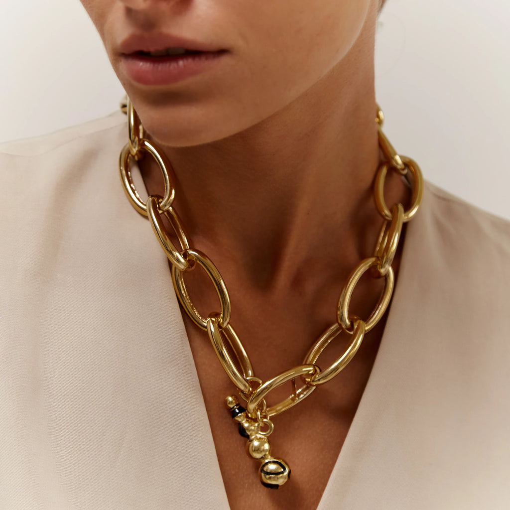 Gold chain necklace with a pendant worn by a person 