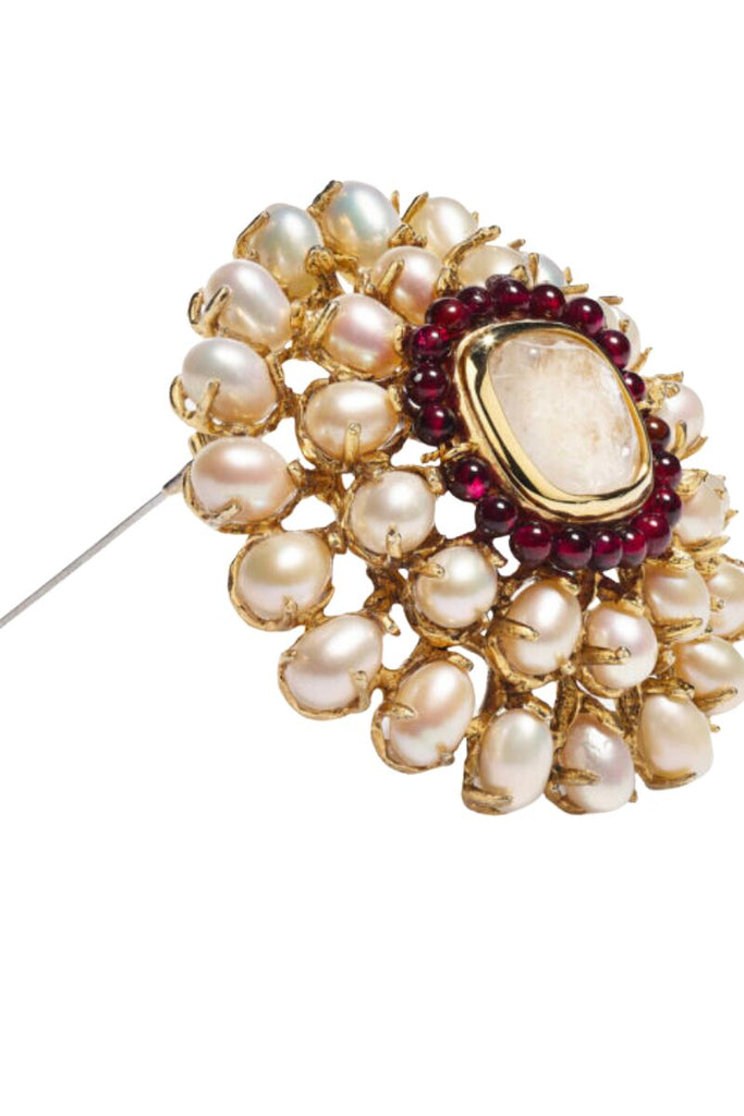 The Perles Baroques line is a stunning collection inspired by the Renaissance era, featuring natural white baroque freshwater pearls, rock crystal cabochons, and deep red garnet pearls, with the standout piece being the modern and elegant Perle Baroque Brooch.