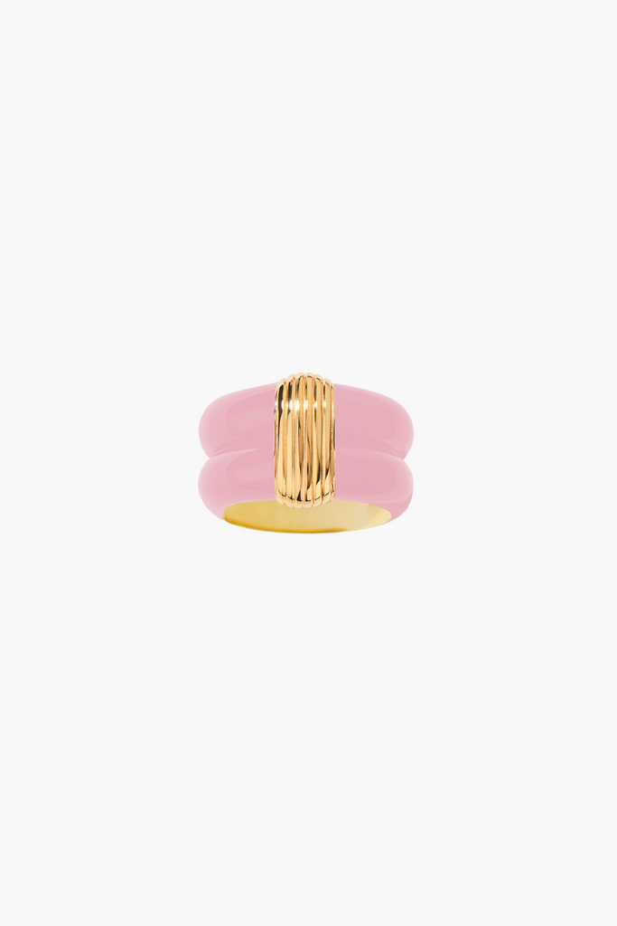 The Katt Rose Ring by Aurélie Bidermann is a bold statement piece with a large pink resin stone set in a gold-plated band, inspired by ancient Egypt and handcrafted in France.