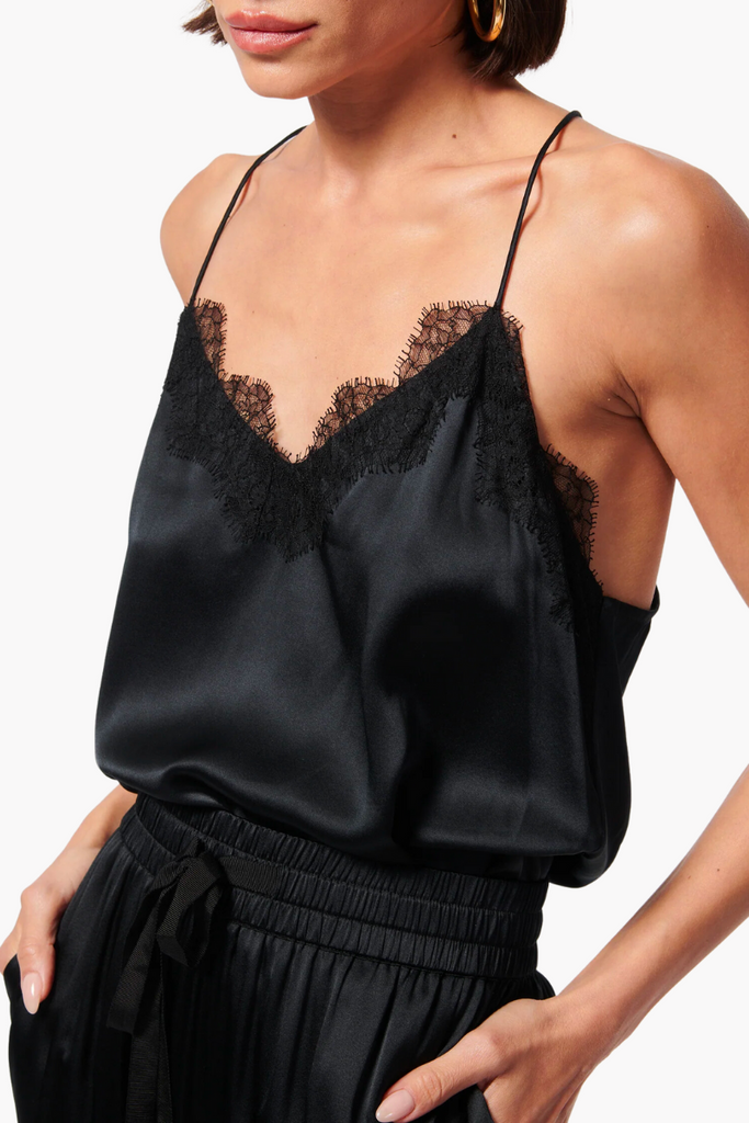 The Racer Charmeuse Cami by Cami NYC is a versatile and luxurious wardrobe essential made from silk sandwash charmeuse, featuring a delicate V-neckline with feminine French lace trimming and a relaxed fitting bodice, perfect for any occasion and available in timeless black.