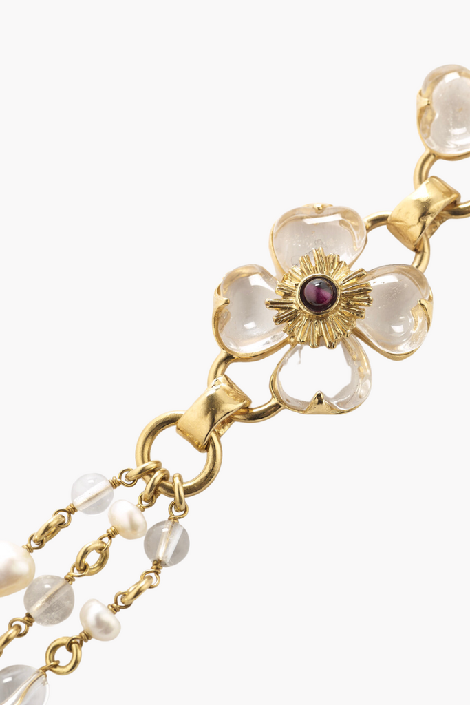 The Trefle Long Necklace by the House of Goossens is an exquisite and feminine lucky charm, featuring three clovers crafted from rock crystal stones, garnets, freshwater pearls, and rock crystal pearls on a 24-carat gold bathed brass chain.