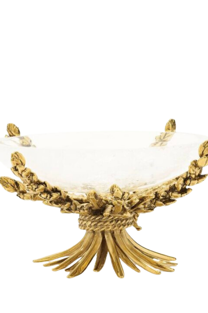The Wheat Cup by Goossens Paris is a stunning rock crystal cup adorned with delicate ears of wheat in metal and intricate motifs of shell, coral, foliage, and water lily, featuring a pedestal bathed in 24-carat gold for a radiant yellow gold finish.