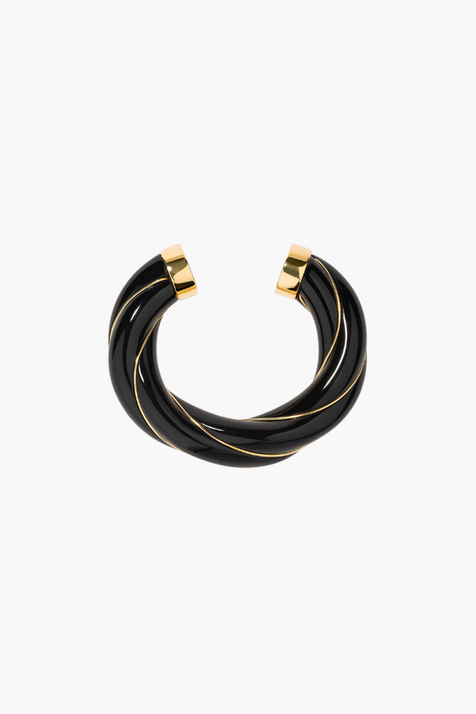 The XL Black Diana Bangle from the Aurélie Bidermann is a bold and elegant statement piece inspired by the hippie torques of the 1960s, featuring a twisted black bakelite bangle covered in a 750/1000 yellow gold thread that twists and turns like a liana or wisteria vine.