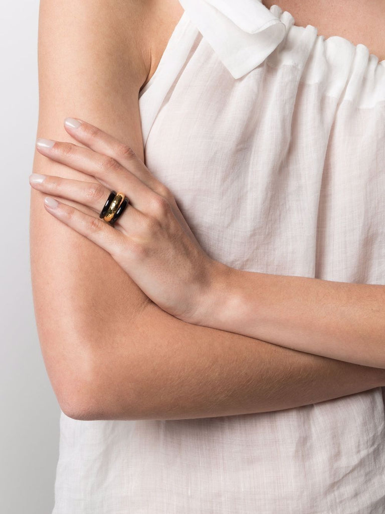 The Aurelie Bidermann Black Nazca Ring is a statement piece that features black resin and gold-plated brass, with a striking design that adds edgy elegance to any outfit.